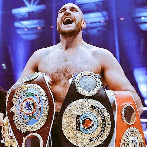 Tyson Fury holding his boxing titles